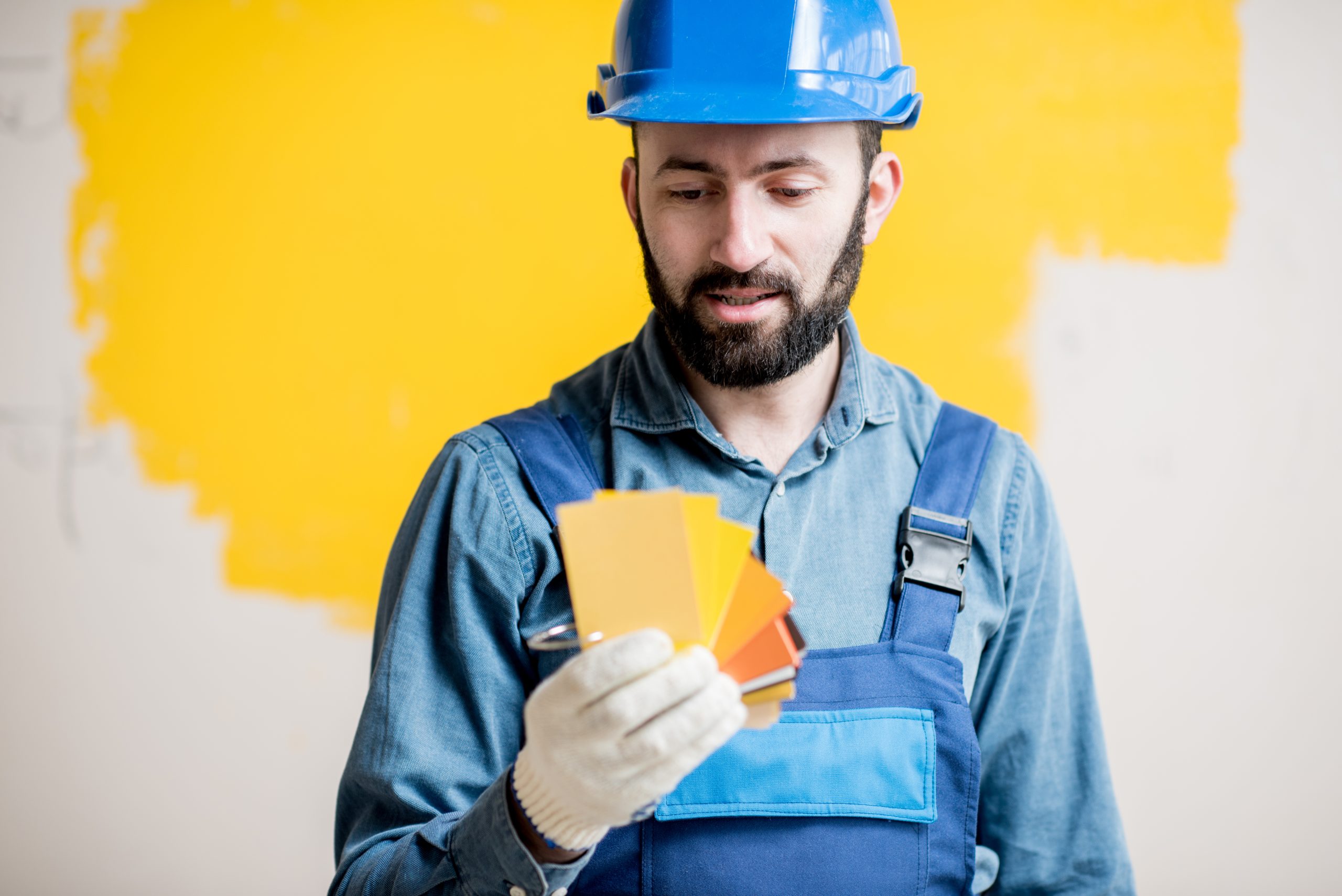 Painter with color swatches indoors Choose roof color