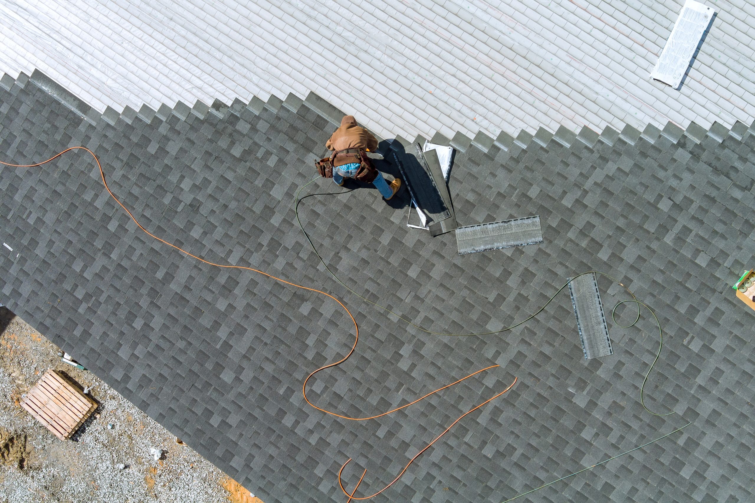 A asphalt shingles installation on the roof roofer is nailing asphalt shingles to roofing construction what to expect when getting a new roof