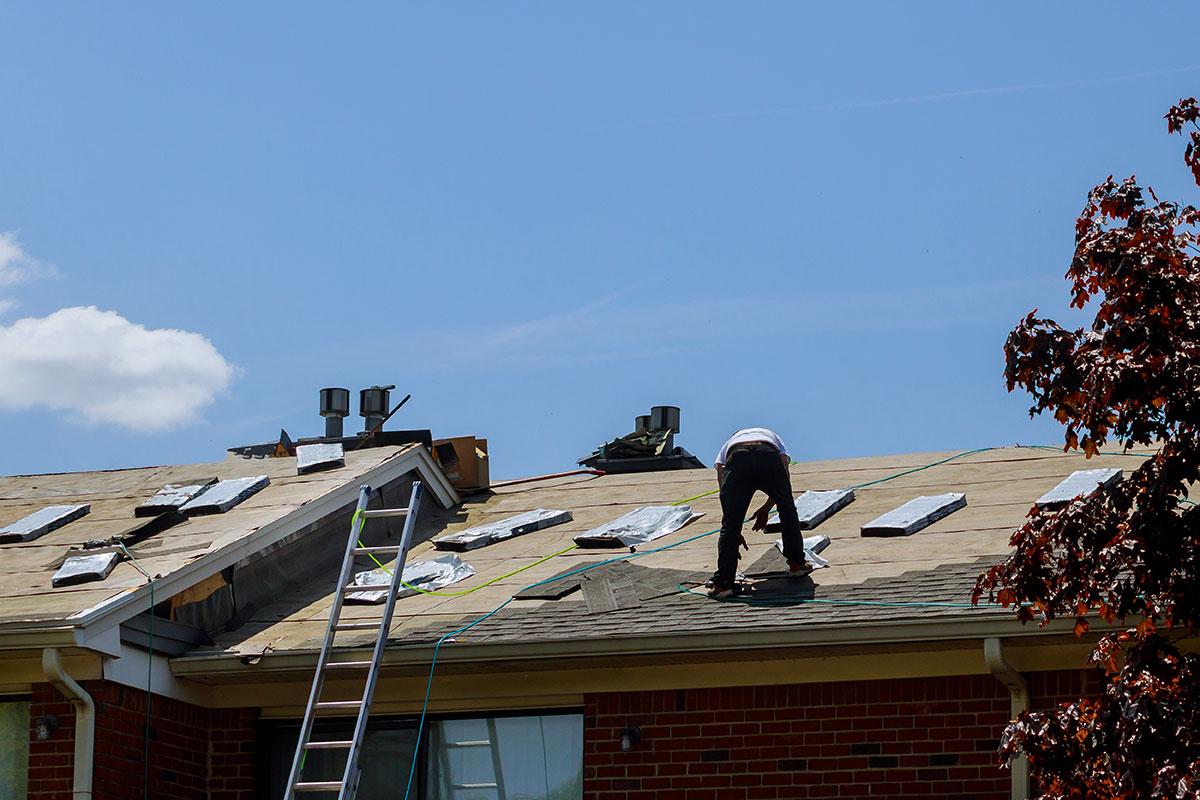 roof-repair-worker-with-replacing-gray-tiles-shin-2022-11-12-10-31-53-utc How to Get Your Roof Ready for Spring