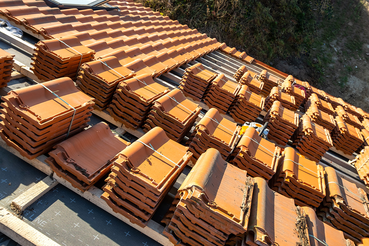 Stacks of yellow ceramic roofing tiles for covering residential What is the Best Commercial Roofing Material?