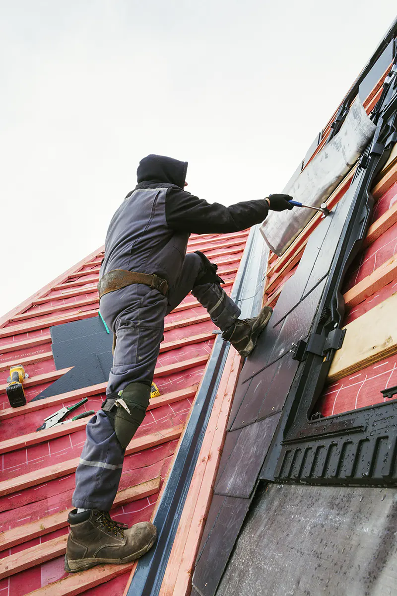 a-roofer-replacing-the-tiles-on-a-house-roof-2025-04-04-21-10-54-utc Excel Construction Group: Roof Repair in Fort Worth