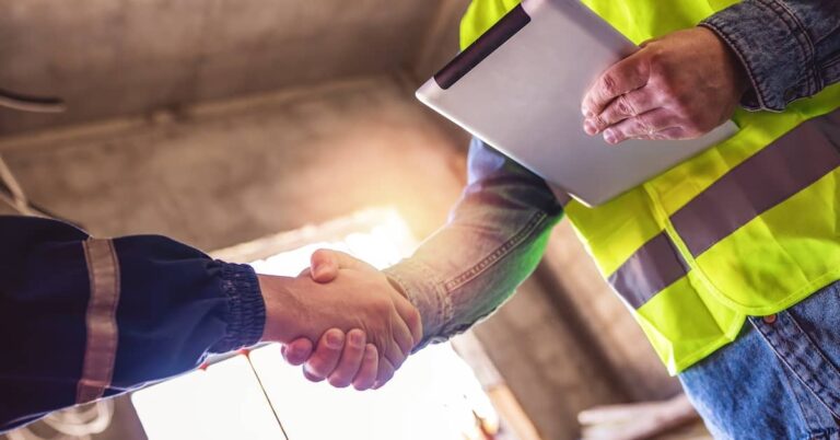two men shaking hands at a construction site